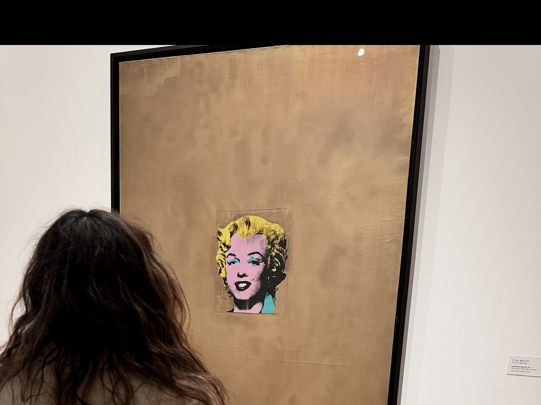 Dr. Tatiana Moreira contemplating Andy Warhol's Gold Marilyn Monroe